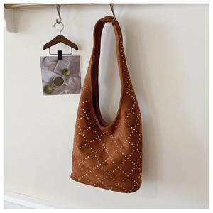 Dettaglio di una borsa hobo in camoscio marrone con borchie argentate e motivo trapuntato