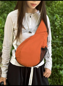 Outdoor orange sling bag with side mesh pocket and adjustable drawstrings for hiking