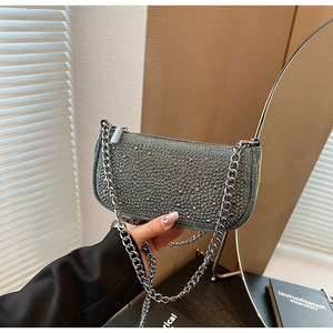 Detail of blue denim underarm bag featuring silver rhinestones and a chunky metal chain