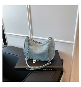 Detailed shot of denim shoulder bag with rhinestone embellishments and chain strap