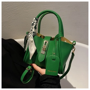Détail du sac seau en cuir vert avec poignée en foulard de soie et boucle dorée