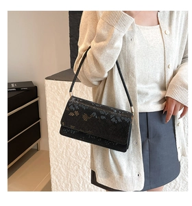 Close-up of black snake pattern texture on a stylish rectangle crossbody handbag