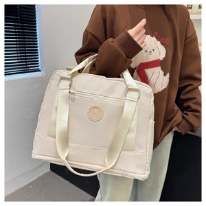 Detail of beige travel tote featuring high-density water-resistant oxford fabric and side pocket