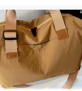 Detailed side view of the earth-tone travel bag featuring nylon texture and embroidery