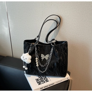 Detail of black tote bag with silver chain, pearl charms, and cute cloud pendant