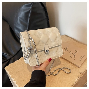 Dettaglio borsa trapuntata beige con catena d'argento e sfera metallica su pietra