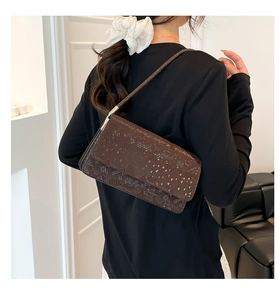 Deep brown snake pattern rectangular baguette bag worn on shoulder by a model