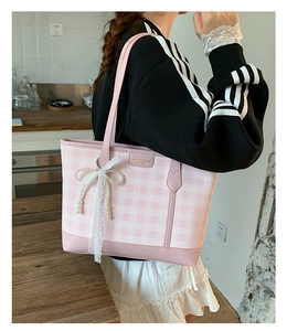 Pink and white checkered tote bag with lace bow detail shown in a casual lifestyle setting
