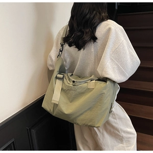 Olive green travel duffel bag with shoulder strap and Hekallbag text detail