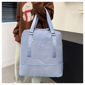 Detail view of large light blue waterproof oxford travel bag with comfortable woven handles