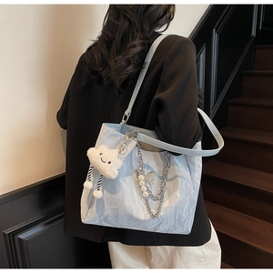 Dettaglio borsa tote plissettata celeste con ciondolo a nuvola soffice e catene in metallo