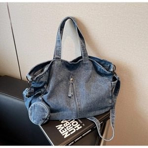 Macro shot of dark denim tote bag with round hanging pouch and vertical zipper pocket
