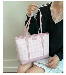 Close-up of pink checkered tote bag featuring premium leather trim and gold metal logo