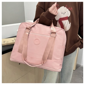 Close-up of pink waterproof travel bag with spacious front zipper pocket and logo