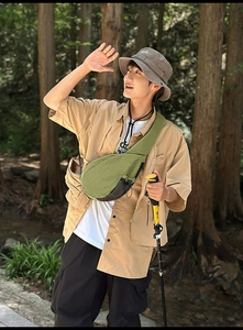 Close-up of green nylon chest bag used for hiking and outdoor activities in the woods