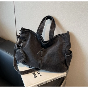 Detail of grey washed denim tote bag with side pockets and a small round coin purse