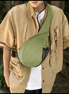 Close-up of olive green oxford fabric chest bag with mesh side pocket and drawstring detail