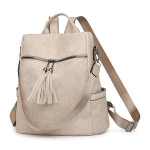 Detail of cream PU leather backpack featuring dual tassel zipper and side pockets