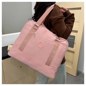 Detail view of pink waterproof oxford travel bag with adjustable strap and metal hardware