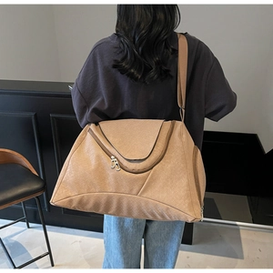 Rückansicht einer khakifarbenen Reisetasche mit Webstruktur und Größenvergleich am Model