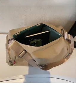 Top view of khaki nylon travel bag showing spacious interior with tablet and notebooks