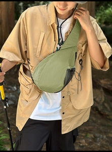 Detail view of green nylon chest bag with mesh water bottle pocket and elastic drawstring