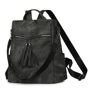 Detail view of the retro black backpack featuring tassel zippers and matte texture finish
