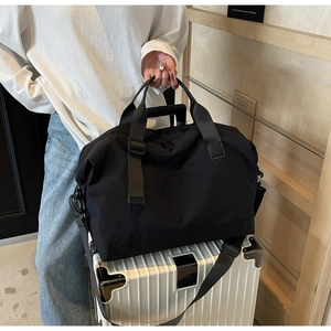 Black travel bag on white suitcase showing luggage handle sleeve functionality