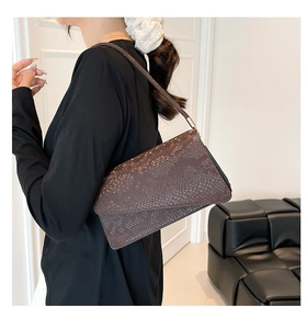 Close-up of brown snakeskin pattern small square bag with gold metal accents