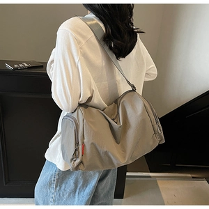 Detail of grey nylon sports duffel bag with side zipper pocket and wrinkled texture