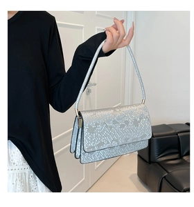 Detail of silver snake-pattern rectangular shoulder bag with metallic scale texture