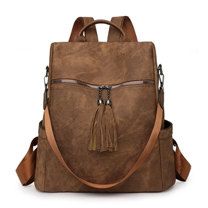 Detail view of deep brown vintage backpack with tassels and versatile strap options