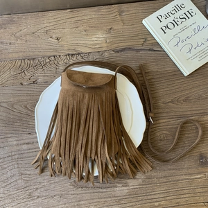 Detailed top view of brown faux suede crossbody bag with long fringes and flap closure
