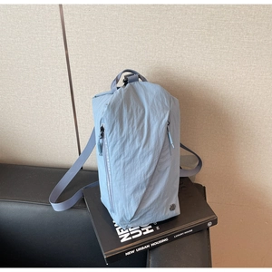 Detail of grey-blue canvas bag showing water-resistant fabric and zipper pocket