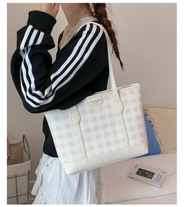 Detail of checkered tote bag featuring gold FASHION & BAGS LEATHER logo and slim shoulder strap
