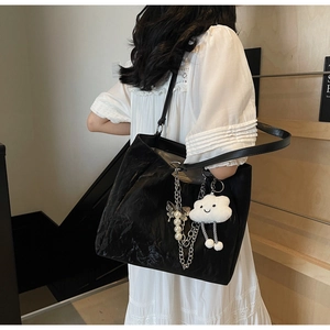 Dettaglio borsa shopper nera con catena argento, perle e ciondolo a nuvola di peluche