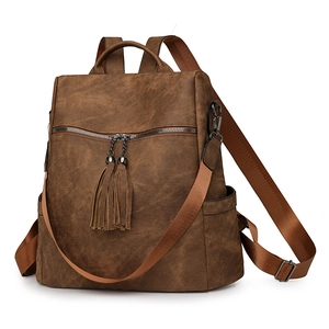 Detail view of brown faux leather backpack with long tassels and durable metal zippers