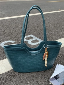 Dark teal hand-woven large tote bag with elegant wooden bead charm on shoulder strap