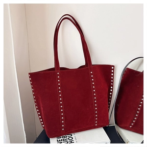Detail of dark red suede tote bag featuring silver rivet studs and dual shoulder straps