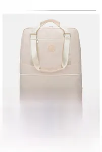 Detail of off-white travel bag showing expandable bottom zipper and durable nylon texture