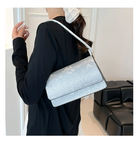Detail of silver faux leather shoulder bag with fine snakeskin texture and metallic finish