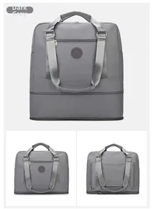 Detail of dark grey waterproof travel bag showing the expandable bottom layer and zippers