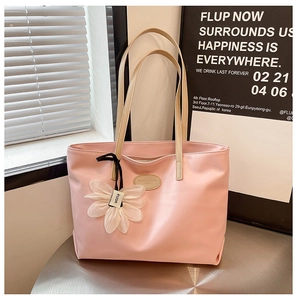 Pink minimalist tote bag detail with long shoulder straps and white floral charm