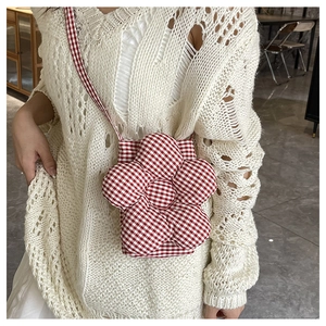 Détail d'un sac bandoulière en forme de fleur à carreaux rouges et blancs en coton