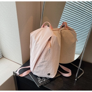 Detail of light pink nylon backpack with geometric folding design and slant zipper