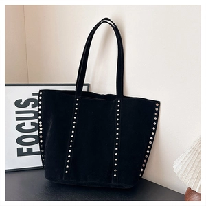 Detail of silver rivets on black suede tote bag with spacious interior and double handles
