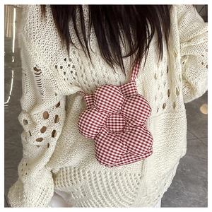 Détail du petit sac à bandoulière en forme de fleur à carreaux rouges et blancs