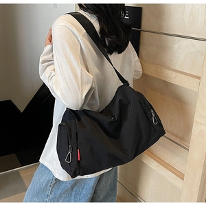 Close-up of black nylon gym bag with silver zipper and distinctive red woven label detail