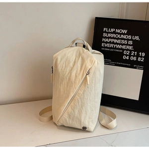 Detail of beige nylon crossbody bag with diagonal zipper and adjustable strap