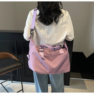 Purple canvas duffel bag with adjustable strap and brand logo for travel and fitness